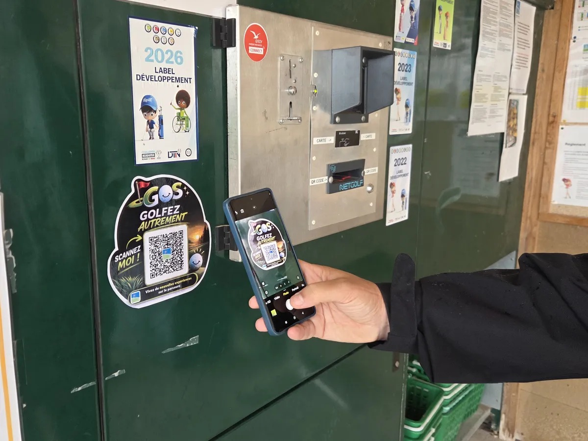 Un joueur scanne le QR Game of Swing coll&eacute; sur le distributeur de balles du Golf du Fort